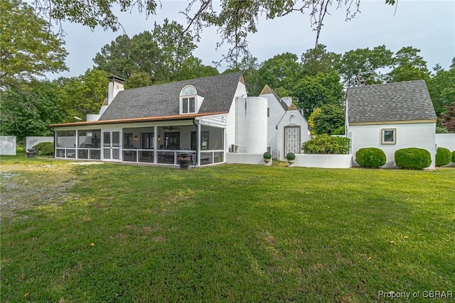 1083 Ottoman Ferry Rd, Mollusk, VA 22503 - rear view of property featuring a sunroom, a chimney, a lawn, and a shingled roof
