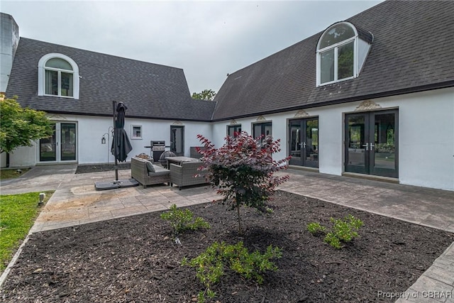 1083 Ottoman Ferry Rd, Mollusk, VA 22503 - back of property featuring french doors, a shingled roof, a patio, outdoor lounge area, and stucco siding