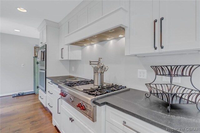 1083 Ottoman Ferry Rd, Mollusk, VA 22503 - kitchen featuring stainless steel gas cooktop, white cabinets, recessed lighting, wood finished floors, and baseboards