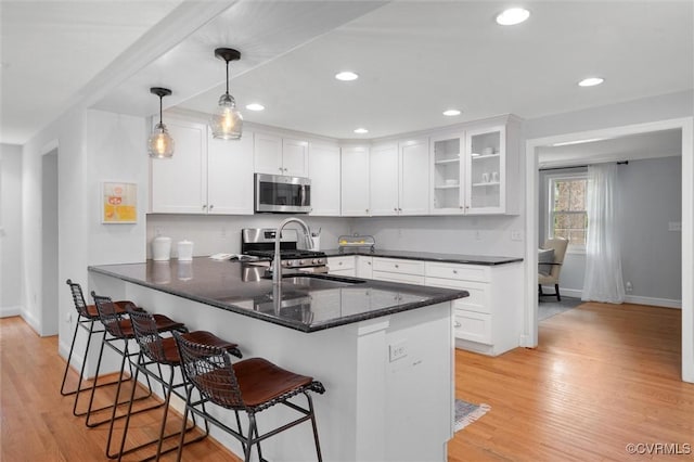 1004 Dinwiddie Ave, Henrico, VA 23229 - kitchen featuring appliances with stainless steel finishes, a sink, baseboards, a peninsula, and white cabinets