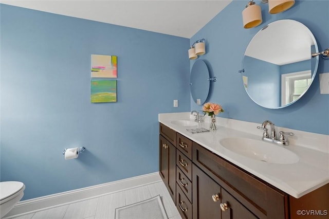 1004 Dinwiddie Ave, Henrico, VA 23229 - bathroom featuring toilet, double vanity, and baseboards