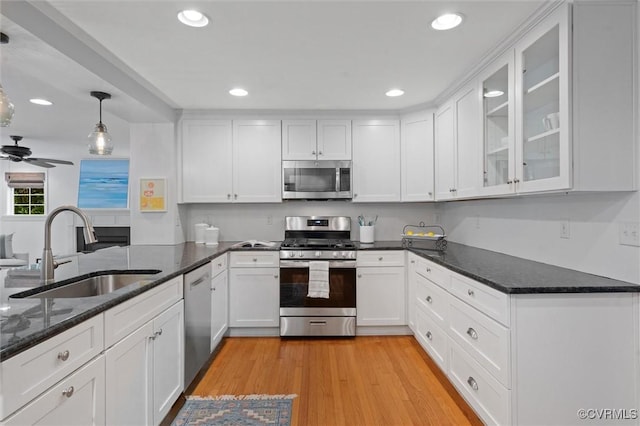 1004 Dinwiddie Ave, Henrico, VA 23229 - kitchen featuring appliances with stainless steel finishes, a sink, white cabinets, dark stone countertops, and glass insert cabinets