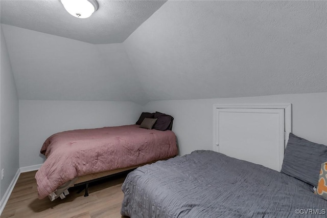 1222 Hull Harbor Rd, Heathsville, VA 22473 - bedroom with wood finished floors, vaulted ceiling, and a textured ceiling