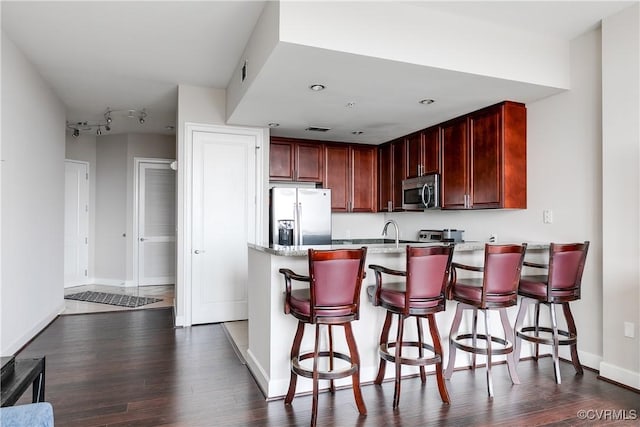 301 Virginia St Unit U806, Richmond, VA 23219 - kitchen featuring stainless steel appliances, dark wood-type flooring, a peninsula, dark brown cabinets, and baseboards