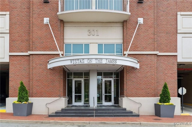 301 Virginia St Unit U806, Richmond, VA 23219 - view of exterior entry featuring brick siding, a balcony, and french doors
