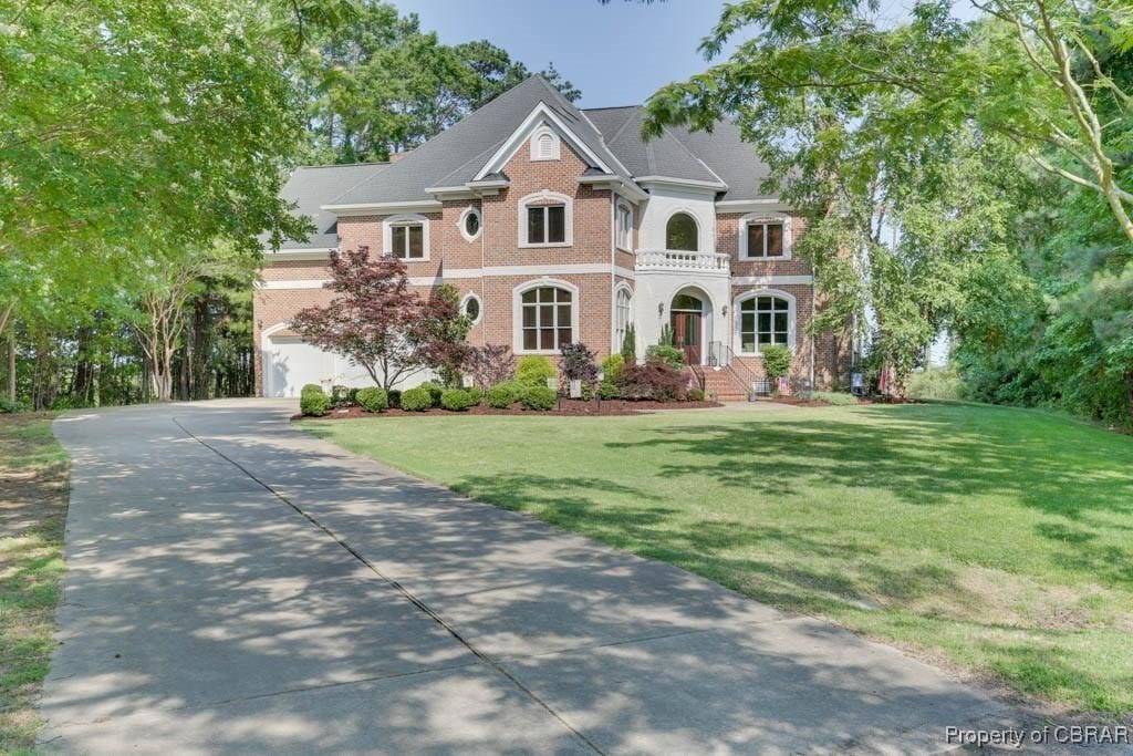 3 Venture Ln, Hampton, VA 23664 - colonial home with driveway, a front lawn, an attached garage, and brick siding