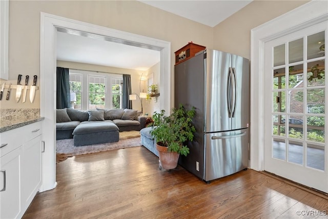 1942 Berkeley Ave, Petersburg, VA 23805 - kitchen with freestanding refrigerator, dark wood-style floors, white cabinets, and light stone counters