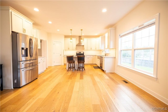 12194 Elnora Ln, Glen Allen, VA 23059 - kitchen with appliances with stainless steel finishes, a breakfast bar area, light wood-style flooring, white cabinetry, and recessed lighting