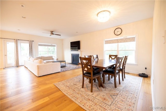 12194 Elnora Ln, Glen Allen, VA 23059 - dining room featuring a glass covered fireplace, light wood finished floors, a ceiling fan, and baseboards