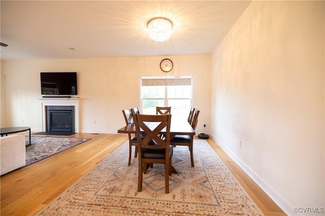 12194 Elnora Ln, Glen Allen, VA 23059 - dining area featuring wood finished floors, a fireplace with flush hearth, a chandelier, and baseboards