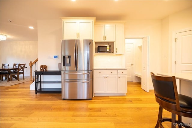 12194 Elnora Ln, Glen Allen, VA 23059 - kitchen featuring appliances with stainless steel finishes, light wood-style flooring, recessed lighting, white cabinetry, and light countertops