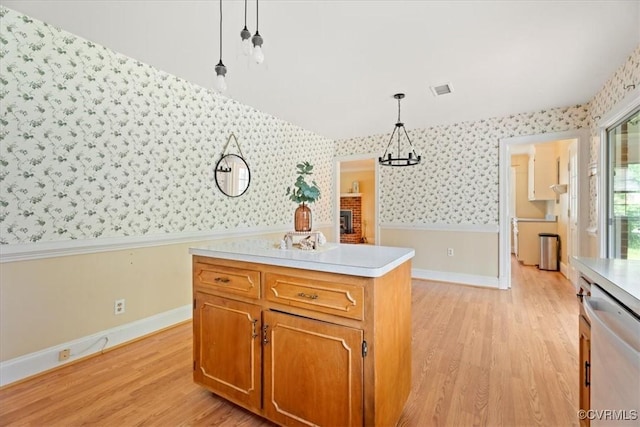 2861 Three Bridge Rd, Powhatan, VA 23139 - kitchen with wallpapered walls, stainless steel dishwasher, light wood-style floors, light countertops, and wainscoting