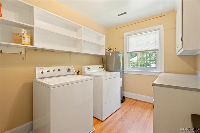 2861 Three Bridge Rd, Powhatan, VA 23139 - washroom with independent washer and dryer, light wood-style floors, cabinet space, baseboards, and water heater