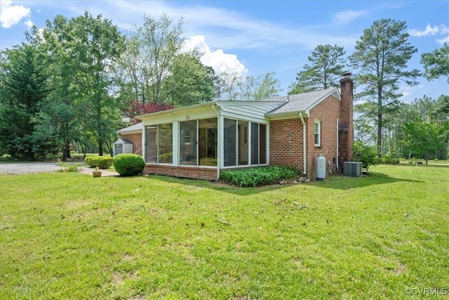 2861 Three Bridge Rd, Powhatan, VA 23139 - back of house featuring a sunroom, brick siding, a chimney, and a yard