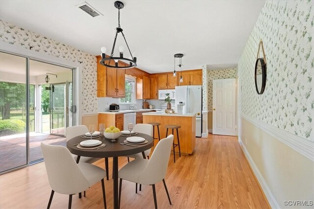 2861 Three Bridge Rd, Powhatan, VA 23139 - dining room featuring wallpapered walls, a chandelier, light wood-type flooring, and a wainscoted wall