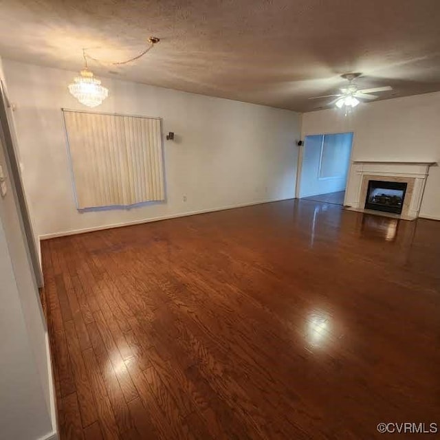 7408 First Landing Ct, Henrico, VA 23231 - unfurnished living room featuring dark wood-type flooring, a glass covered fireplace, ceiling fan, and a chandelier