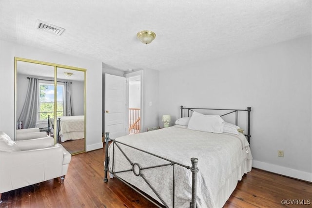 24405 N James Madison Hwy, New Canton, VA 23123 - bedroom with wood finished floors, baseboards, a closet, and a textured ceiling