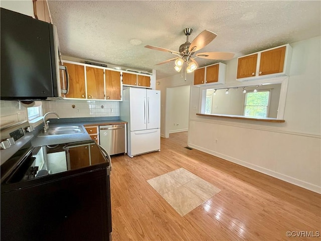 241 Levelfield Ln, Lancaster, VA 22503 - kitchen featuring appliances with stainless steel finishes, a sink, a textured ceiling, brown cabinetry, and a ceiling fan