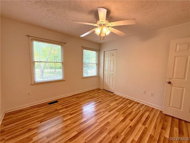 241 Levelfield Ln, Lancaster, VA 22503 - spare room with light wood-type flooring, a textured ceiling, a ceiling fan, and baseboards
