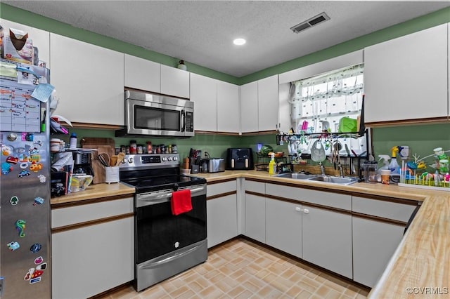 106 S Marion Ave Unit A, Hopewell, VA 23860 - kitchen featuring appliances with stainless steel finishes, light countertops, white cabinets, recessed lighting, and a textured ceiling