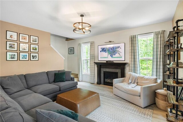 2401 Willowvale Pl, Midlothian, VA 23112 - living area with healthy amount of natural light, light wood-type flooring, a chandelier, and a glass covered fireplace