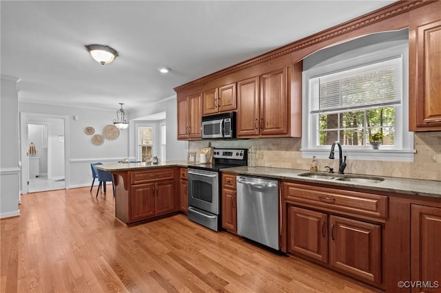 4709 Pompton Ln, Chester, VA 23831 - kitchen featuring appliances with stainless steel finishes, a sink, a peninsula, brown cabinetry, and decorative backsplash
