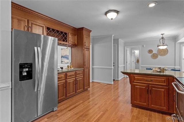 4709 Pompton Ln, Chester, VA 23831 - kitchen featuring stainless steel appliances, brown cabinets, crown molding, light wood finished floors, and a wainscoted wall