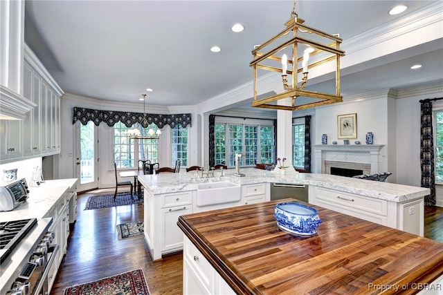 1921 Miln House Rd, Williamsburg, VA 23185 - kitchen with a center island, butcher block countertops, a sink, dark wood-style flooring, and ornamental molding