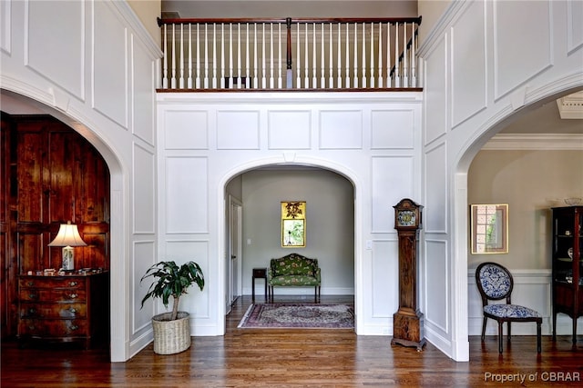 1921 Miln House Rd, Williamsburg, VA 23185 - foyer entrance with arched walkways, a decorative wall, wood finished floors, a towering ceiling, and crown molding