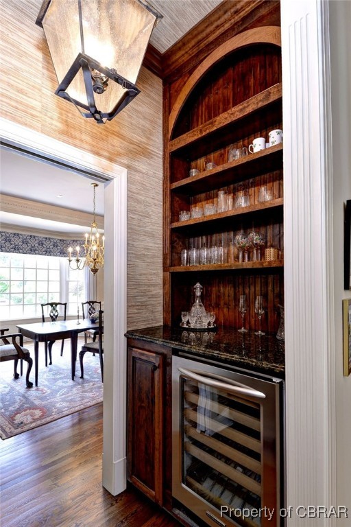 1921 Miln House Rd, Williamsburg, VA 23185 - indoor dry bar featuring wine cooler, dark wood-style flooring, a chandelier, and wooden walls