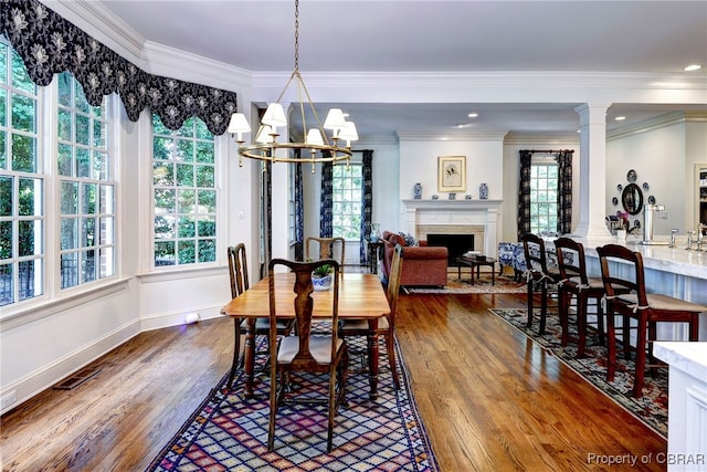 1921 Miln House Rd, Williamsburg, VA 23185 - dining room featuring wood finished floors, a chandelier, a fireplace, crown molding, and baseboards