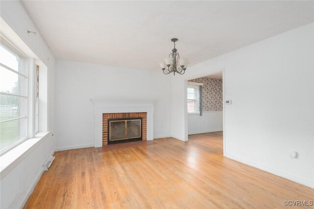 8005 Three Chopt Rd, Henrico, VA 23229 - unfurnished living room featuring a chandelier, a fireplace, light wood finished floors, and baseboards