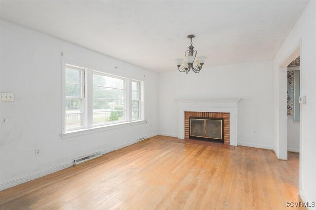 8005 Three Chopt Rd, Henrico, VA 23229 - unfurnished living room featuring light wood-style floors, a chandelier, baseboards, and a brick fireplace