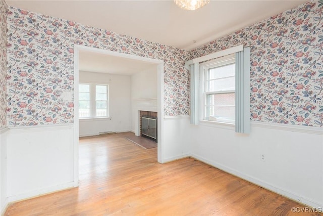 8005 Three Chopt Rd, Henrico, VA 23229 - unfurnished living room with wallpapered walls, light wood-style flooring, a fireplace with flush hearth, baseboards, and wainscoting