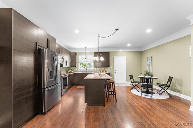 3104 1st Ave, Richmond, VA 23222 - kitchen with stainless steel appliances, a kitchen breakfast bar, a kitchen island, a chandelier, and dark wood-type flooring