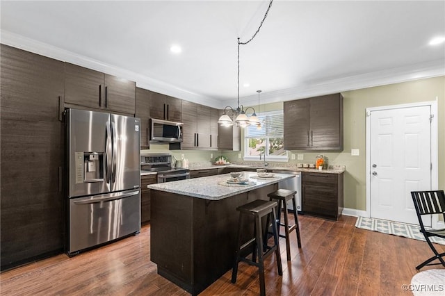 3104 1st Ave, Richmond, VA 23222 - kitchen with appliances with stainless steel finishes, a breakfast bar area, a center island, dark brown cabinets, and crown molding