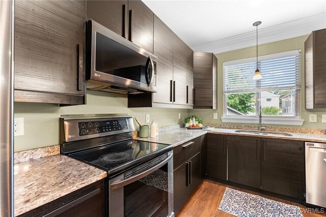 3104 1st Ave, Richmond, VA 23222 - kitchen with appliances with stainless steel finishes, a sink, light wood finished floors, ornamental molding, and dark brown cabinets