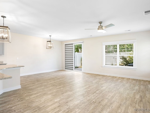 3216 Gannet Ln, Midlothian, VA 23112 - unfurnished living room with light wood-style floors, a ceiling fan, and a chandelier