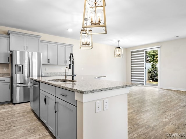 3216 Gannet Ln, Midlothian, VA 23112 - kitchen featuring appliances with stainless steel finishes, gray cabinets, light stone counters, a kitchen island with sink, and light wood-style flooring