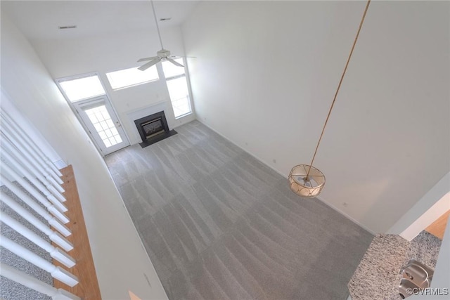 10504 Bishops Gate Dr, Glen Allen, VA 23059 - unfurnished living room with carpet floors, ceiling fan, a fireplace with flush hearth, and a high ceiling