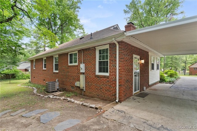 6405 Hagueman Dr, Richmond, VA 23225 - view of property exterior featuring brick siding, a chimney, a carport, and central AC