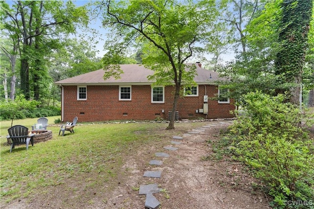 6405 Hagueman Dr, Richmond, VA 23225 - rear view of house featuring crawl space, a fire pit, brick siding, and a lawn