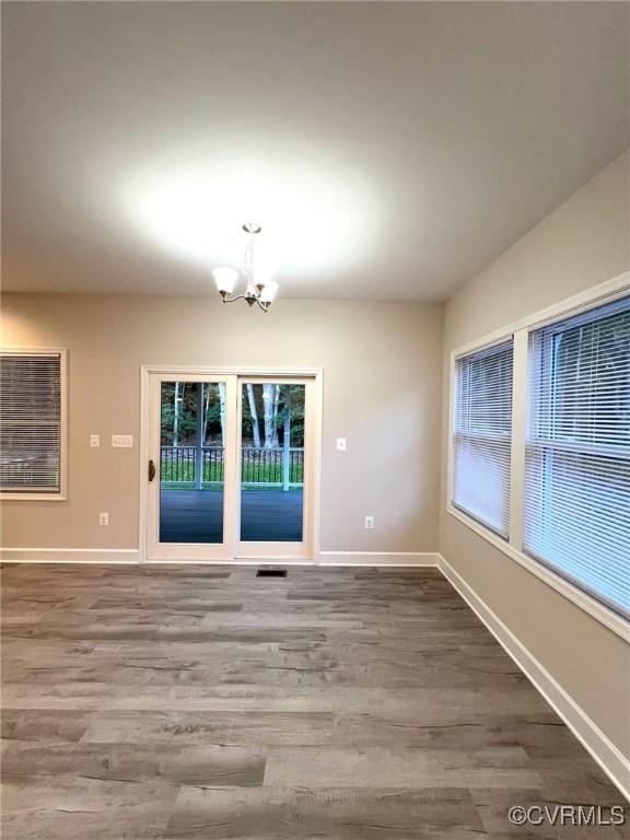 94 Dingley Rd, Montross, VA 22520 - unfurnished dining area featuring a chandelier, wood finished floors, and baseboards