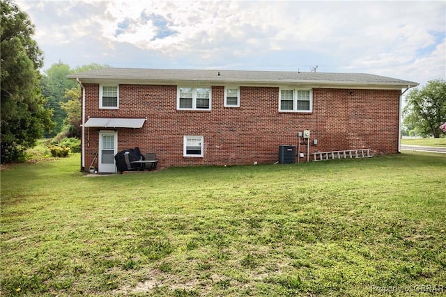 7486 Roaring Springs Rd, Gloucester, VA 23062 - rear view of property featuring a yard, central AC unit, and brick siding