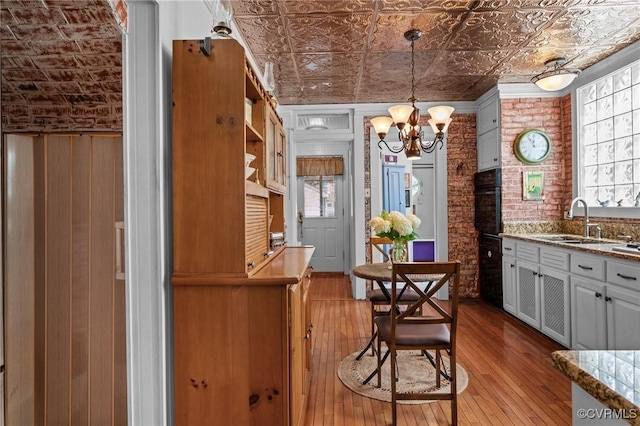 1520 Bellevue Ave, Richmond, VA 23227 - kitchen with hardwood / wood-style floors, an ornate ceiling, a chandelier, light stone counters, and black oven
