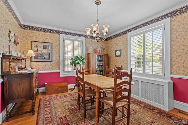 1520 Bellevue Ave, Richmond, VA 23227 - dining area with crown molding, radiator, wood finished floors, wallpapered walls, and a chandelier