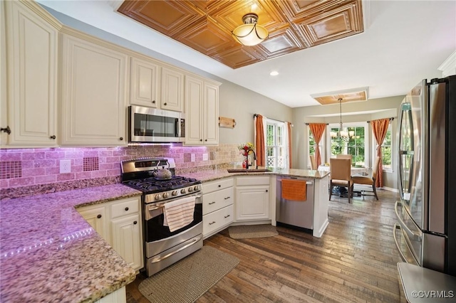 8390 Bink Pl, Mechanicsville, VA 23111 - kitchen featuring appliances with stainless steel finishes, a peninsula, a sink, decorative backsplash, and light stone countertops