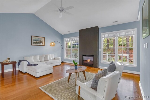 118 Old Field Rd, Irvington, VA 22480 - living room featuring vaulted ceiling, a large fireplace, wood finished floors, ceiling fan, and baseboards