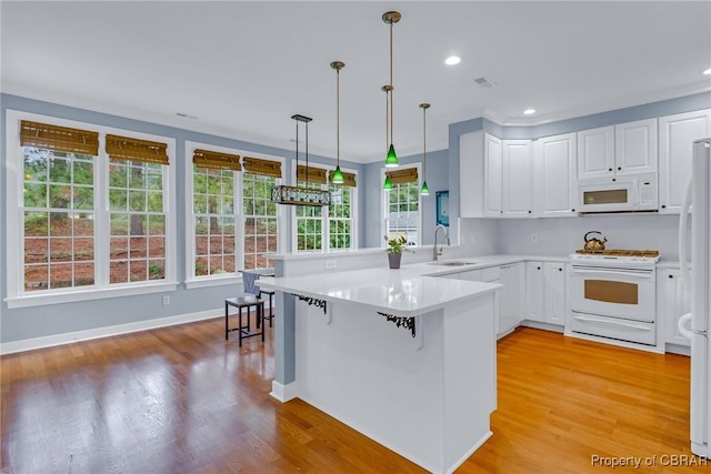 118 Old Field Rd, Irvington, VA 22480 - kitchen with white appliances, a peninsula, a sink, light wood finished floors, and recessed lighting