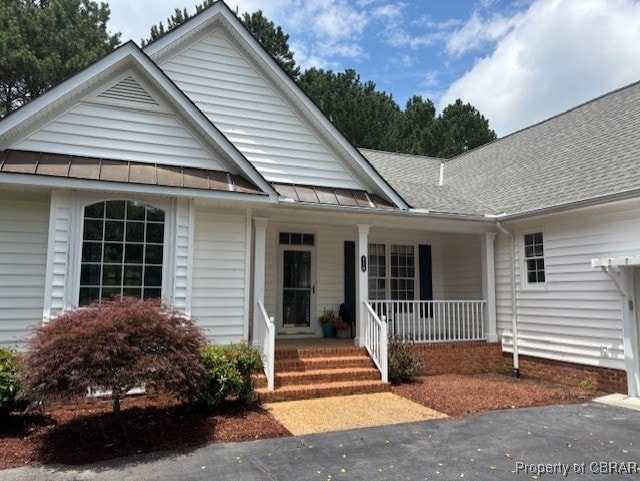 118 Old Field Rd, Irvington, VA 22480 - ranch-style house with a standing seam roof, covered porch, roof with shingles, and metal roof